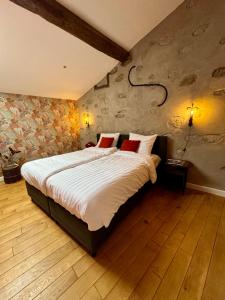 ein Schlafzimmer mit einem großen Bett mit weißer Bettwäsche und roten Kissen in der Unterkunft Pax et Amor Chambres d'hôtes de charme - Charming B&B in Mazerolles-du-Razès