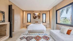 een slaapkamer met een wit bed en een bank bij Villa les Palmiers in Marrakesh +73 foto's