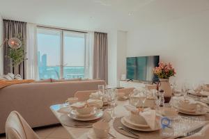 Capital Stay - 2 Bed Apartment in Dubai Festival City في دبي: غرفة معيشة مع طاولة وأريكة