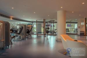 einen Fitnessraum mit Laufbändern und Crosstrainern in einem Gebäude in der Unterkunft Capital Stay - 2 Bed Apartment in Dubai Festival City in Dubai