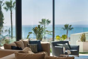 sala de estar con sofá y ventana grande en 200m² NEW Villa F with private, heated pool and amazing ocean view., en Adeje