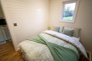 a bedroom with a bed and a window at Luxury Pod Cabin in beautiful surroundings Wrexham in Wrexham