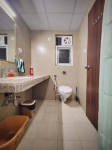 a bathroom with a sink and a toilet in it at Symphony Apartments at MIHAN Nagpur in Nagpur