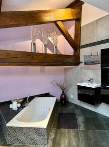 ein großes Bad mit einer Badewanne und einem Waschbecken in der Unterkunft Pax et Amor Chambres d'hôtes de charme - Charming B&B in Mazerolles-du-Razès