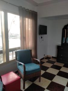 uma sala de estar com uma cadeira e uma televisão em Jasmine Nile Sky Hotel em Cairo