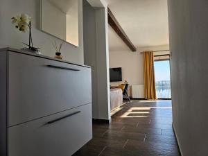 a kitchen with a white dresser and a living room at Kuća za odmor Sabljaci in Ogulin