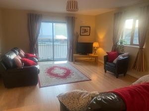 a living room with a couch and chairs and a television at Luxury Town House-Apartment Carrick-on-shannon in Carrick on Shannon