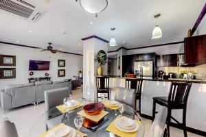een keuken en een woonkamer met een glazen tafel en stoelen bij Diamante del Sol 402S in Jacó
