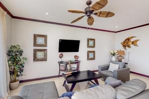 a living room with a couch and a ceiling fan at Diamante del Sol 402S in Jacó