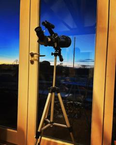 a camera on a tripod in front of a window at West Lodge Cottage in Morpeth