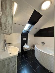 a bathroom with a tub and a sink and a toilet at Sweet Life Wellness Apartments in Egerszalók