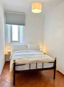 um quarto com uma cama num quarto com uma janela em Portuguese village apartment - Casa Martins No.54 em Freiria