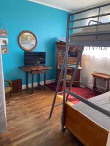 1 dormitorio con litera y escritorio con espejo en Maison 4 pers 100m de la plage, en Trégunc