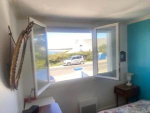 1 dormitorio con ventana y vistas a la calle en Maison 4 pers 100m de la plage, en Trégunc