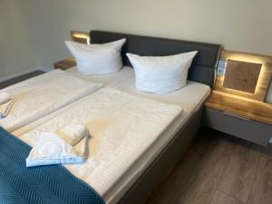two beds with white sheets and pillows in a room at Hotel Pommerscher Hof in Zinnowitz