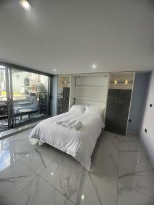 a large white bed in a room with a large window at Mara Boutique Apartments 1 in Oldbury