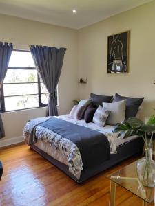 um quarto com uma cama grande e uma janela em One Three Nine On Roberts em Pietermaritzburg