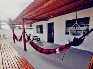 eine Hängematte auf einer Veranda eines Hauses in der Unterkunft Casa de Praia Em Aracaju,Se in Barra dos Coqueiros