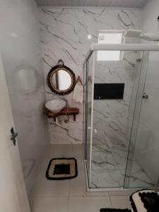 uma casa de banho com um chuveiro, um espelho e um lavatório. em Casa de Praia Em Aracaju,Se em Barra dos Coqueiros