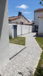 a walkway in front of a white building at Casa alquiler temporario Necochea in Necochea