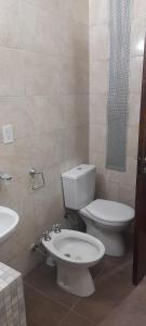 a bathroom with a toilet and a sink at Casa alquiler temporario Necochea in Necochea