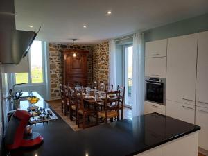 a kitchen and dining room with a table and chairs at Maison au cœur de notre ferme familiale in Asson