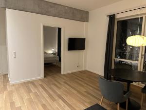 a living room with a table and a room with a bed at City apartment Dæmningen Vejle in Vejle