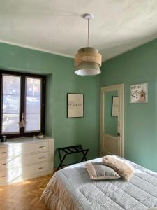ein Schlafzimmer mit grünen Wänden und einem großen Bett in der Unterkunft Bilocale a due passi dal centro in Limone Piemonte