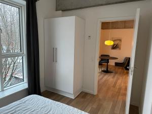 a bedroom with a white cupboard and a table at City apartment Dæmningen Vejle in Vejle