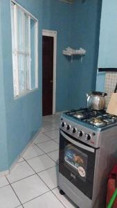 a kitchen with a stove and a blue wall at Villa 64 in Quezaltepeque