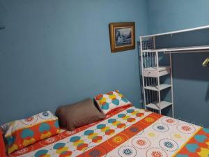 a bedroom with a bed and a blue wall at Villa 64 in Quezaltepeque