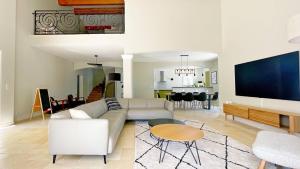 uma sala de estar com um sofá e uma televisão em Villa des Chardonnerets em Mougins