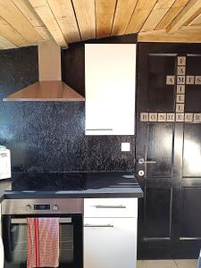 a kitchen with a stove top oven next to a door at Le P'tit Nid : Mini loft pour 2 à 4 personnes in Tellin