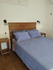 Casas Arena y Sol - FRENTE AL MAR في باركي ديل بلاتا: غرفة نوم بسرير من الشراشف الزرقاء ومصباحين