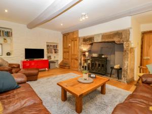 a living room with a couch and a fireplace at Pentre Court Cottage in Abergavenny