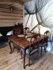 un tavolo e sedie in legno in una stanza di Le P'tit Nid : Mini loft pour 2 à 4 personnes a Tellin