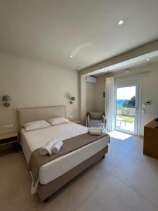 a bedroom with a large bed with towels on it at Corfu valley view in Paleokastritsa