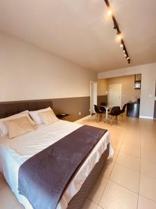 a bedroom with a large bed and a table and chairs at Excutive apartamentos in Joinville