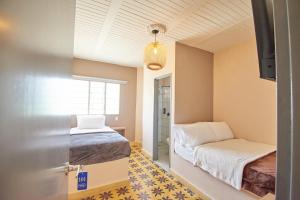 sypialnia z 2 łóżkami i oknem w obiekcie HOTEL LOZETA w mieście Carmen de Viboral