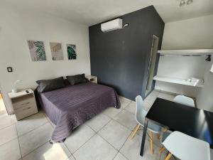 1 dormitorio con 1 cama, mesa y sillas en MAKTUB DEPARTAMENTOS Y HABITACIONES en Alta Gracia