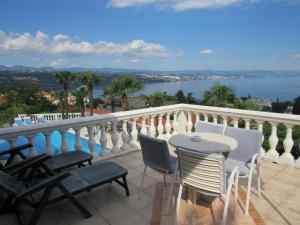 a balcony with a table and chairs and a view of the water at Villa Palme 1 in Opatija