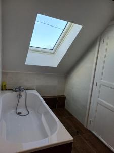 a skylight in a bathroom with a bath tub at Maison au cœur de notre ferme familiale in Asson +17 photos