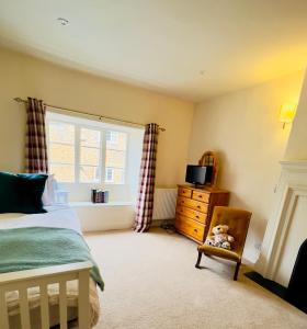 um quarto com uma cama, uma janela e uma cadeira em Large room in Stunning Cottage Edge of the Cotswolds em Bloxham