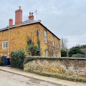 uma antiga casa de tijolos com uma parede de tijolos em Large room in Stunning Cottage Edge of the Cotswolds em Bloxham