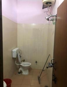 uma casa de banho com um WC branco num quarto em Omjee Paying Guest em Dehradun
