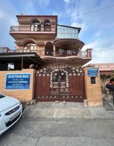 una casa con una puerta y un coche aparcado delante de ella en Omjee Paying Guest, en Dehradun