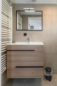een badkamer met een wastafel en een spiegel bij Duinhuysje in Domburg