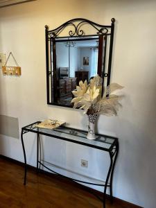 - une table avec un miroir et un vase avec des fleurs dans l'établissement Apartamento Magdalena, à Haro