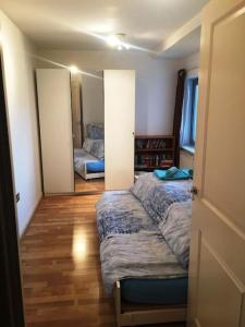 1 Bedroom Flat near Excel, O2, Canary Wharf - London في لندن: غرفة نوم بسريرين ومدخل مع مرآة