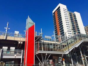 a building with a red sign and a tall building at 1 Bedroom Flat near Excel, O2, Canary Wharf - London in London